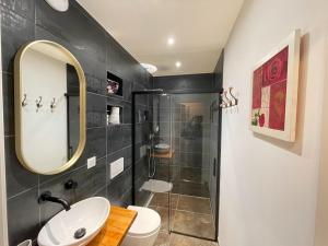 a bathroom with a sink and a toilet and a mirror at Basel Airport Garden in Blotzheim