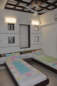a room with two beds in a room at Peaceful Retreat 3BHK For six person in Vadodara