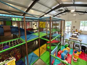 ein großer Indoor-Spielbereich mit vielen verschiedenen Spielgeräten in der Unterkunft Nine Yards Family Glamping @ Farrington's Farm in Bristol