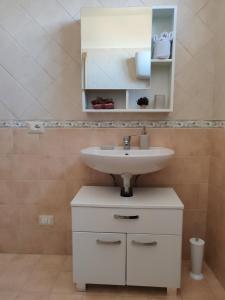 uma casa de banho com um lavatório branco e um espelho. em Dimora Storica em Petrignano
