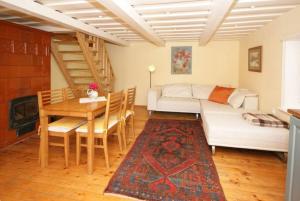 a living room with a couch and a table and a staircase at Authentic Fisherman House in Preila