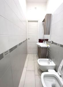 La salle de bains blanche est pourvue de toilettes et d'un lavabo. dans l'établissement Sea House Sorrento(Near the sea) - Around Sorrento, à Meta