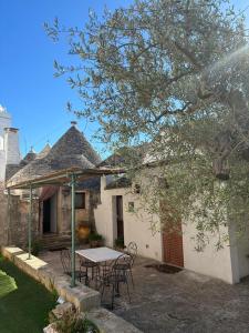 une table et des chaises devant une maison dans l'établissement Trullo Vacanza, à Alberobello