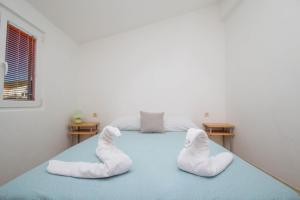 Un dormitorio con una cama con calcetines blancos. en Apartment Kristina en Tribunj