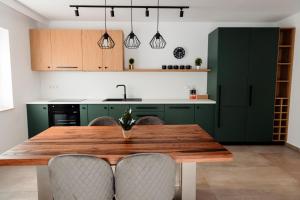 a kitchen with a wooden table and green cabinets at Park View Apartment 1 in Sighetu Marmaţiei