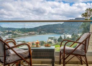 a balcony with two chairs and a table and a view at Panorama Studios in Plakias