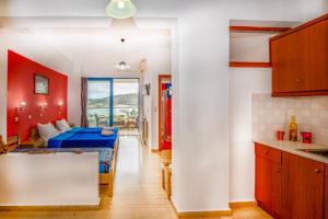 a kitchen and a living room with a bed in a room at Panorama Studios in Plakias