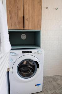 a washing machine with a wooden cabinet above it at Park View Apartment 1 in Sighetu Marmaţiei