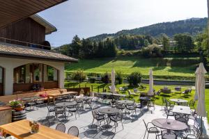 d'une terrasse avec des tables et des chaises offrant une vue sur un champ. dans l'établissement Hotel Nevada, à Bormio