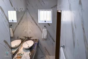 ein Badezimmer mit zwei Waschbecken und zwei Spiegeln in der Unterkunft Pousada Garden das Flores in Chapada dos Guimarães