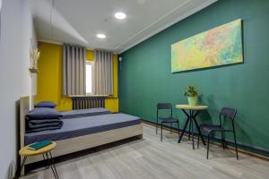 a bedroom with a bed and a table and chairs at People Hostel & Coworking in Bishkek