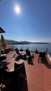 a deck with chairs and a view of the water at Foca Antik Otel in Foça