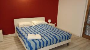 - une chambre dotée d'un lit avec une couverture rayée bleue et blanche dans l'établissement Dolce Dormire, à Enna
