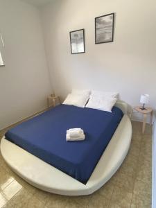 a bedroom with a large bed with a blue comforter at Isabella's Houses in Punta Braccetto