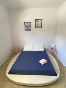- une chambre avec un grand lit et une couverture bleue dans l'établissement Isabella's Houses, à Punta Braccetto
