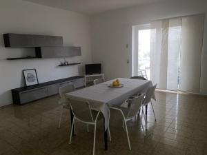 eine Küche und ein Esszimmer mit einem Tisch und Stühlen in der Unterkunft Isabella's Houses in Punta Braccetto