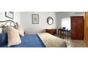 1 dormitorio con 1 cama, vestidor y escritorio en Encantadora Casa Andaluza, en Salobreña