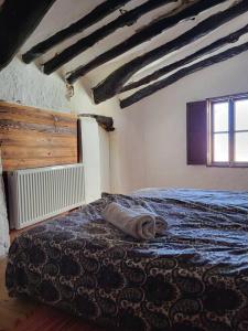 1 dormitorio con 1 cama con manta azul y ventana en Casa Ventura, en Suflí