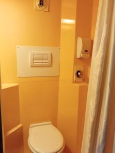 a bathroom with a white toilet and a yellow wall at Premiere Classe Saint Brice Sous Foret in Saint-Brice-sous-For&ecirc;t
