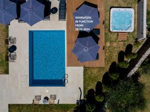 an overhead view of a swimming pool with umbrellas at B&B Vila Sabbia in Lopar