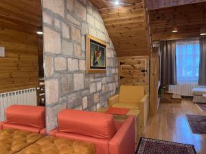 a living room with two chairs and a stone wall at Chalet Kolašin in Kolašin