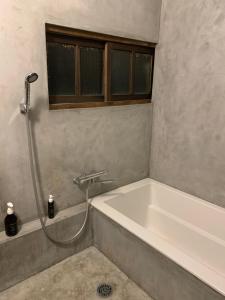 a bathroom with a bath tub with a shower at Jasmine in Hukue