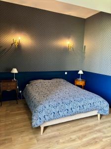 een blauwe slaapkamer met een bed en 2 nachtkastjes bij Gîte Exotique château de la Pervenchère in Casson