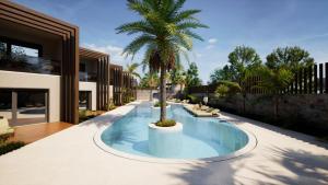 eine Palme in einem Pool neben einem Haus in der Unterkunft Noble Hotel & Suites in Gouves