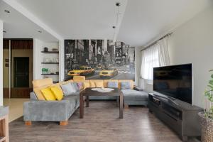 a living room with a couch and a tv at Grand Apartments - Exclusive Beach Apartment in Gdańsk