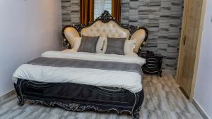 a bedroom with a large bed with a large headboard at California Luxury Hotel & Suite in Ibadan