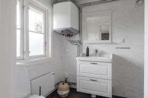 Baño blanco con lavabo y espejo en Smålandsgården, en Gränna