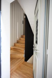 pasillo con suelo de madera y puerta blanca en Vasilicari Apartments en Chios