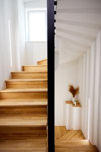 a staircase in a house with wooden floors and a window at Vasilicari Apartments in Chios