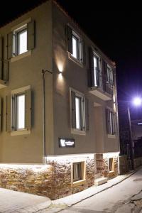 a building with windows on a street at night at Vasilicari Apartments in Chios