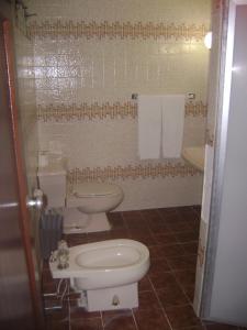 a bathroom with two toilets and a sink at Acapulco Park Hotel in Acapulco