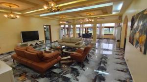 sala de estar con sofás y TV de pantalla plana. en Gaïa Luxury Suites en Libreville