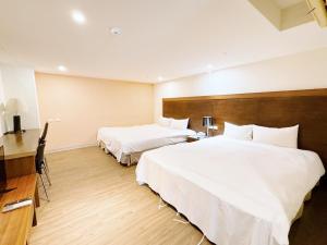 台南的住宿－友愛閤睏漫旅，酒店客房配有两张床和一张书桌