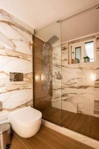 ein Bad mit einem WC und einer Glasdusche in der Unterkunft LoveBirds Rethymno Suite in Rethymno