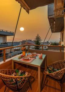 een tafel en 2 stoelen op een balkon bij LoveBirds Rethymno Suite in Rethimnon