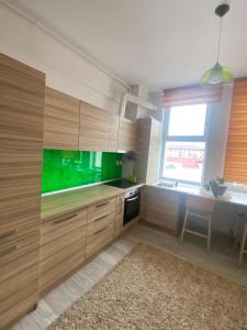 una cucina con armadi in legno e schermo verde di Apartament Claudia a Baia Mare