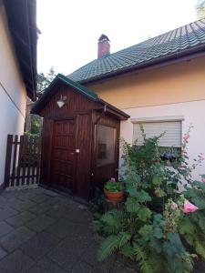 a wooden garage next to a house with a fence at Erholungsoase in Łukęcin