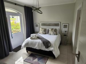 a bedroom with a bed with two teddy bears on it at Caribbean Estates Villa R&R in Port Edward