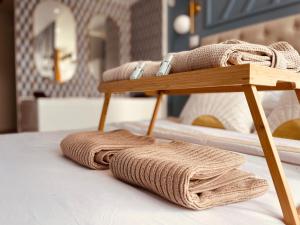 a pile of towels sitting on top of a bed at La balnéo de l'impératrice Anastasia - 306 in Rouen +12 photos