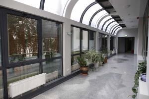 a hallway with windows and potted plants in a building at Apartamenty nad Zalewem 213 in Serock