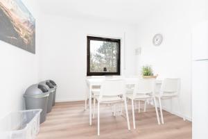 Moderne Ferienwohnung / Monteurswohnung mit 6 Betten in Driedorf/Herborn في Driedorf: غرفة طعام مع طاولة وكراسي بيضاء