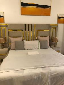 een slaapkamer met een groot wit bed met 2 lampen bij Apartment in Dar es salaam , Mikocheni in Dar es Salaam