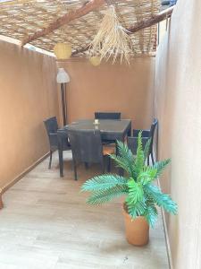 a dining room with a table and a plant at Cosy & magnifique appartement Marrakech in Marrakech