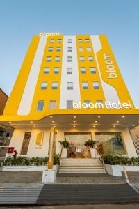 ein gelbes und weißes Gebäude mit einem Willkommensschild darauf in der Unterkunft Bloom Hotel - Ranchi in Ranchi