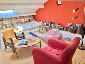 ein Wohnzimmer mit roten Wänden, einem Sofa und Stühlen in der Unterkunft Piscine & Sauna Maison au Coeur de Marseille in Marseille