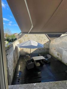 - une table et des chaises avec un parasol sur la terrasse dans l'établissement Appartement avec terrasse, à Vierzon